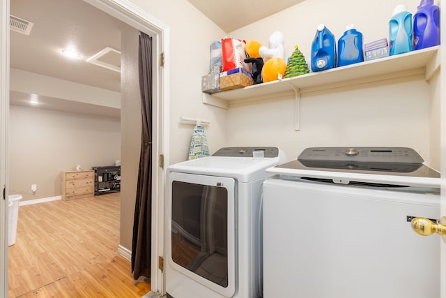 laundry room with washer and dryer and hardwood / wood-style flooring