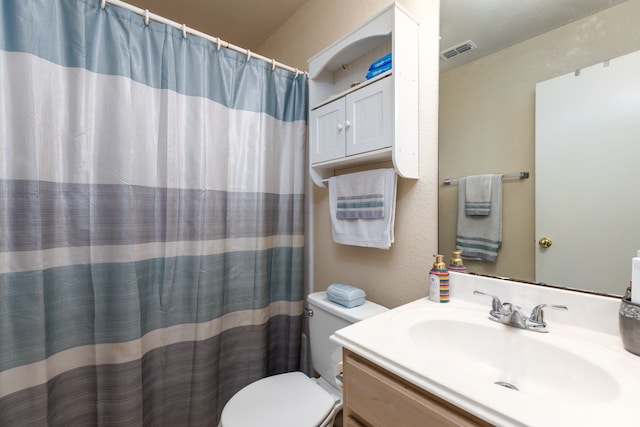 bathroom with vanity, curtained shower, and toilet