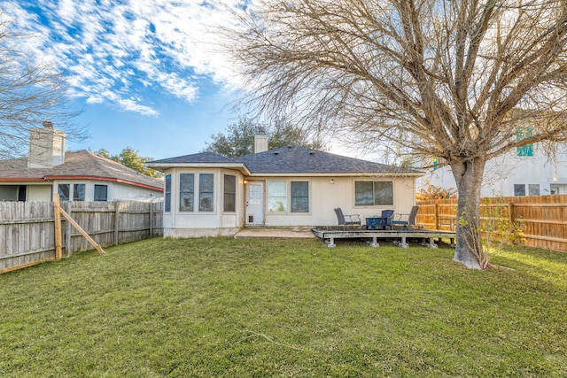 rear view of property featuring a wooden deck and a yard