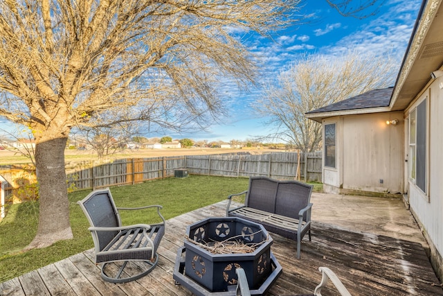 wooden terrace featuring a yard and a fire pit