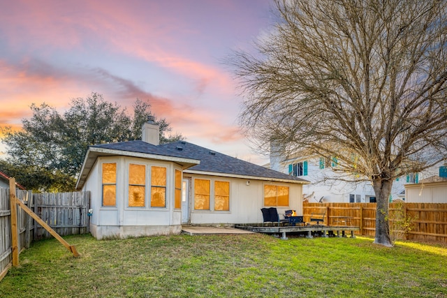 back house at dusk with a yard