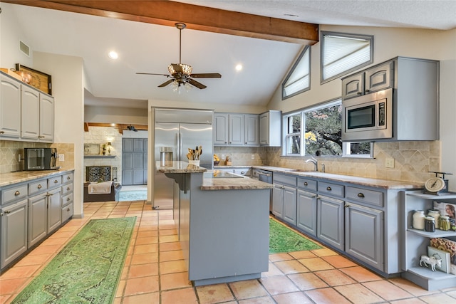 kitchen with built in appliances, ceiling fan, a center island, and gray cabinetry