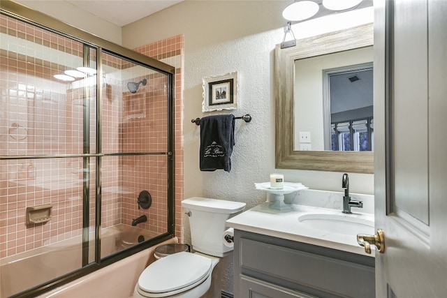 222 Winn Valley Dr, Wimberley, TX 78676 - full bathroom featuring a textured wall, vanity, shower / bath combination with glass door, and toilet