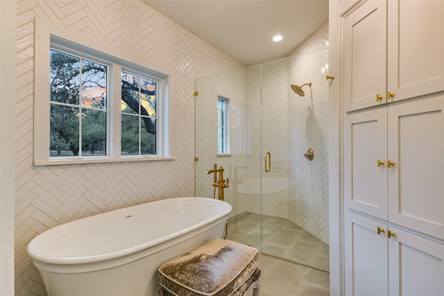 bathroom featuring tile patterned floors, tile walls, and plus walk in shower