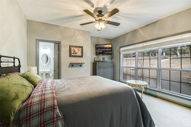 carpeted bedroom featuring ceiling fan, sink, and ensuite bathroom