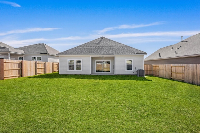 rear view of house with a yard and central AC unit