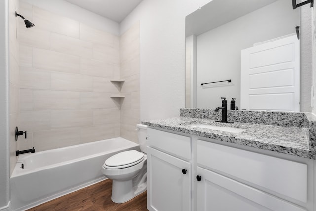 full bathroom with hardwood / wood-style floors, vanity, toilet, and tiled shower / bath