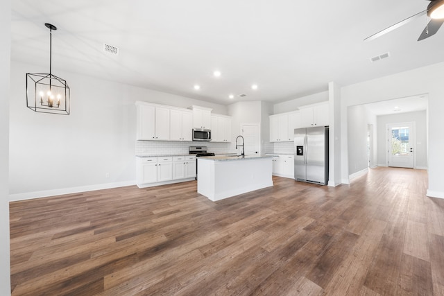 kitchen featuring sink, stainless steel appliances, white cabinetry, and an island with sink