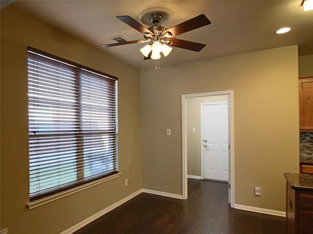 empty room with dark wood-type flooring and ceiling fan