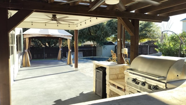 view of patio / terrace with a gazebo, area for grilling, a grill, and a shed