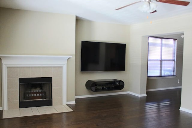 unfurnished living room featuring ceiling fan, a fireplace, and dark hardwood / wood-style flooring