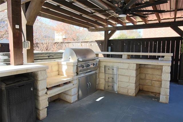 view of patio featuring a grill, ceiling fan, and exterior kitchen