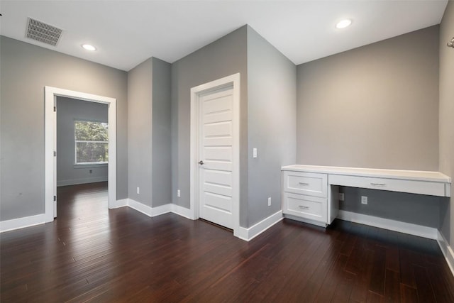 unfurnished office featuring dark wood-style flooring, recessed lighting, visible vents, built in study area, and baseboards