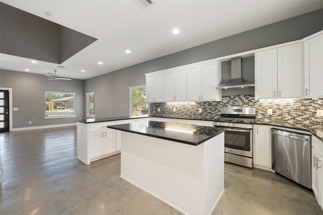 kitchen with stainless steel appliances, wall chimney range hood, decorative backsplash, and finished concrete flooring