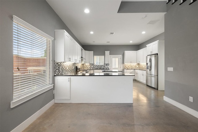 kitchen with baseboards, concrete floors, backsplash, and stainless steel fridge with ice dispenser