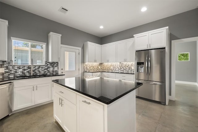 kitchen featuring visible vents, appliances with stainless steel finishes, white cabinets, and a sink