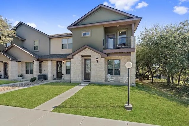 view of front of property featuring a balcony and a front yard