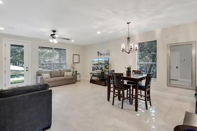 dining space with ceiling fan with notable chandelier