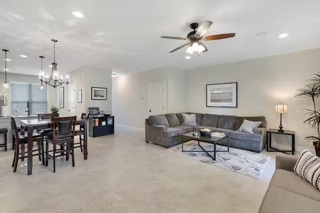 living room featuring ceiling fan with notable chandelier