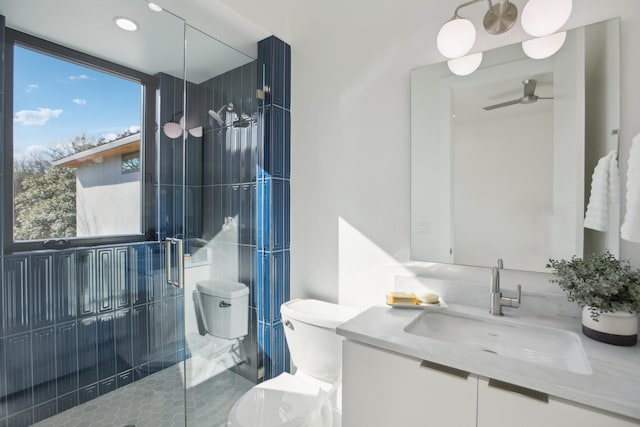 bathroom featuring vanity, toilet, an enclosed shower, and a wealth of natural light