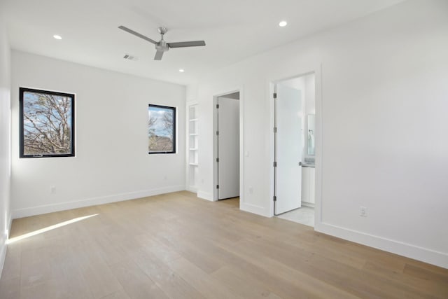 unfurnished bedroom with ceiling fan, ensuite bath, and light hardwood / wood-style floors