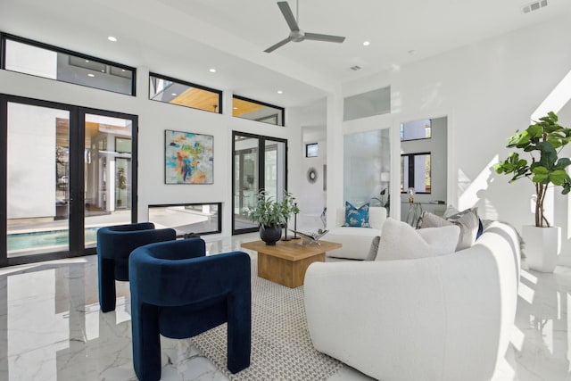 living room featuring french doors, ceiling fan, plenty of natural light, and a high ceiling