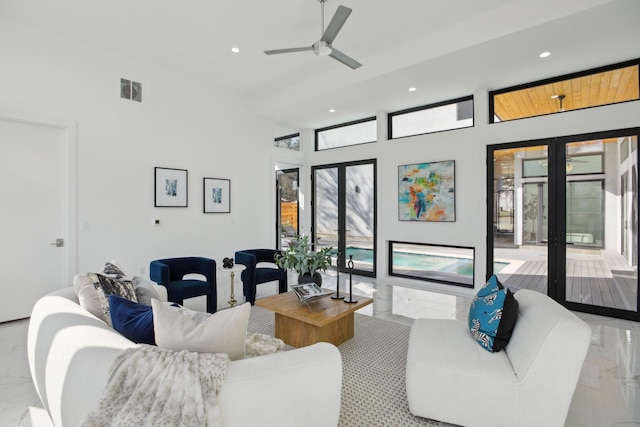 living room featuring a towering ceiling, french doors, and ceiling fan