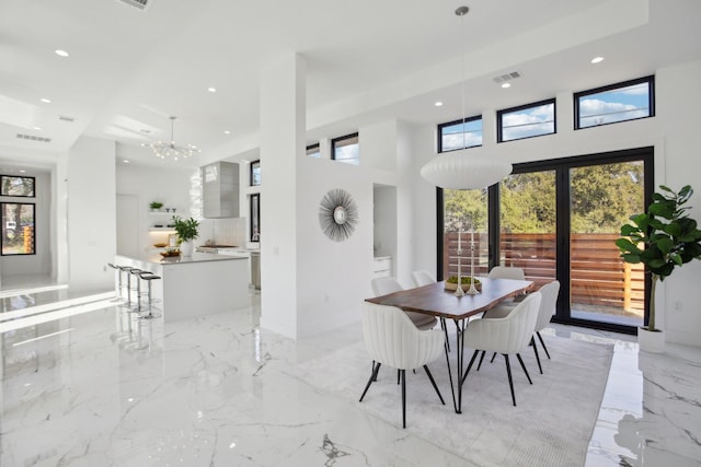 dining room with an inviting chandelier and a high ceiling