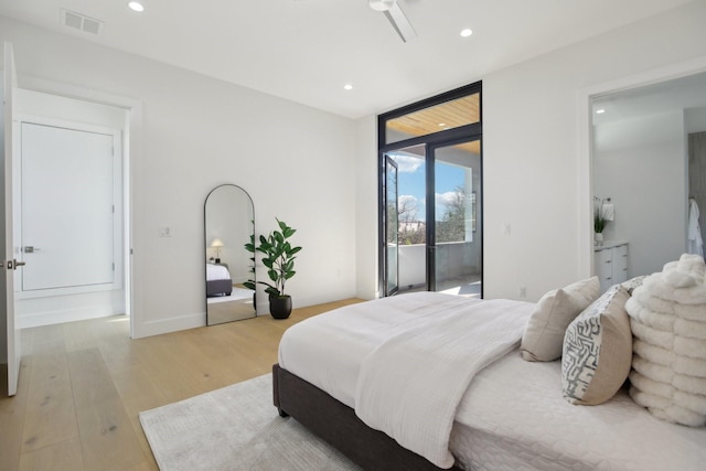 bedroom with access to outside, a wall of windows, and light wood-type flooring