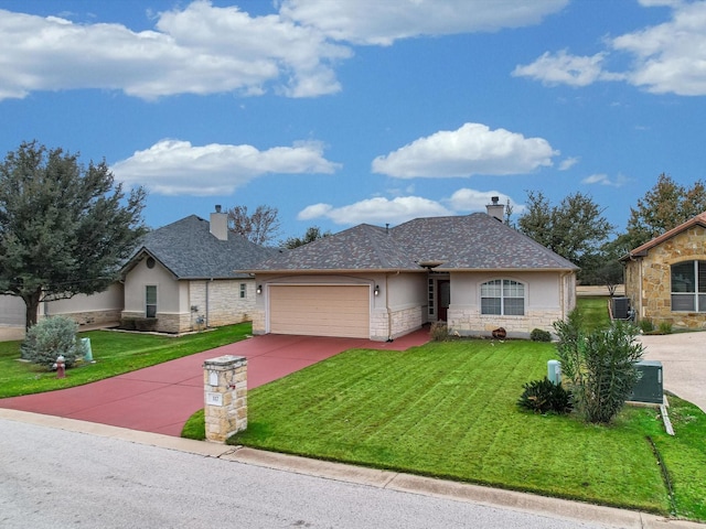 view of front of home with a front yard, central AC, and a garage