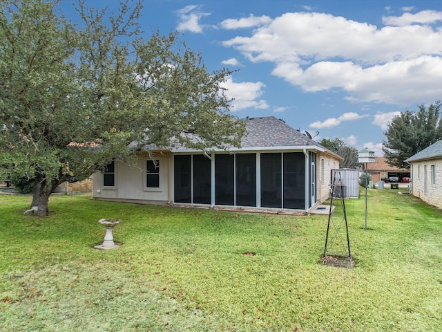 rear view of house with a lawn and a sunroom