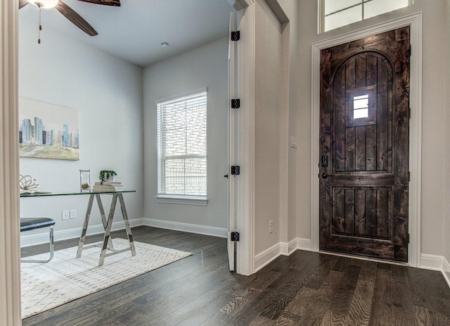 foyer entrance with ceiling fan and dark wood-type flooring