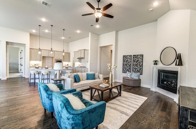 living room featuring dark hardwood / wood-style floors, ceiling fan, and sink