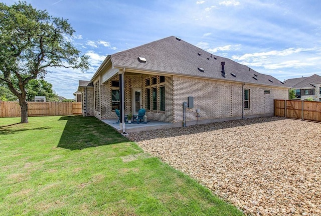 rear view of house featuring a yard and a patio