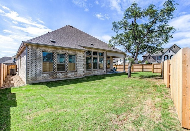 back of property featuring central AC and a lawn