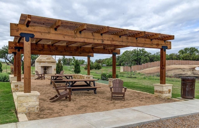 view of patio featuring an outdoor stone fireplace and a pergola