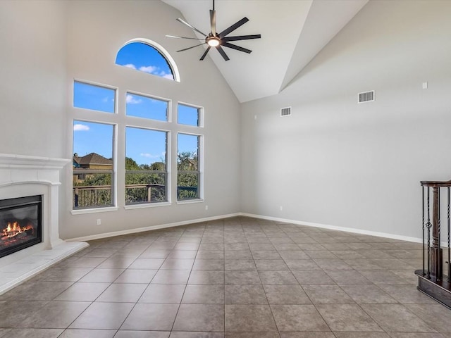 unfurnished living room with ceiling fan, a fireplace, visible vents, and baseboards