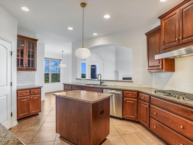 kitchen with appliances with stainless steel finishes, light tile patterned flooring, a sink, and decorative backsplash