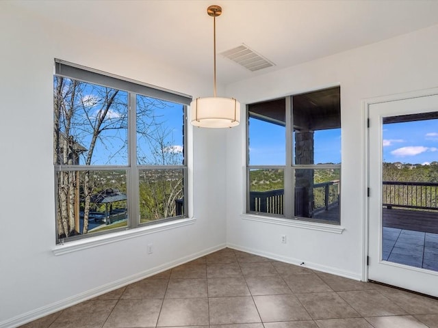 unfurnished dining area with baseboards, visible vents, and tile patterned floors