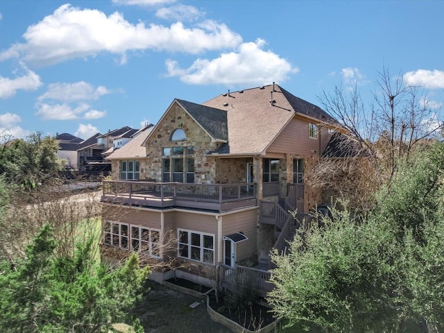 rear view of house featuring stone siding