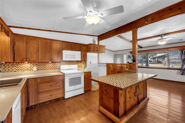 kitchen featuring vaulted ceiling with beams, white appliances, a center island, and sink