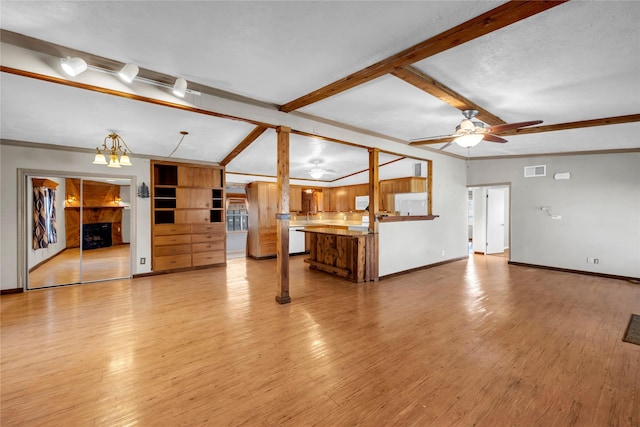 unfurnished living room featuring light wood-type flooring, built in shelves, ceiling fan with notable chandelier, crown molding, and vaulted ceiling with beams