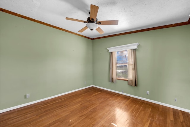 empty room with a textured ceiling, ceiling fan, wood-type flooring, and ornamental molding