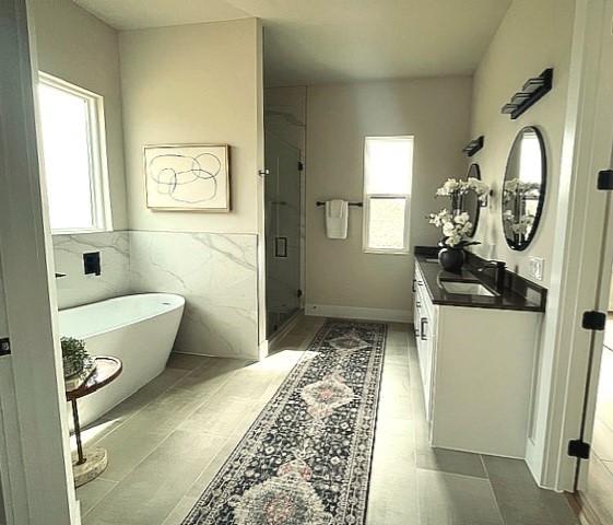 bathroom with vanity, tile walls, and shower with separate bathtub