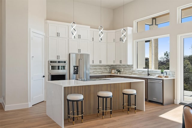 kitchen with white cabinetry, stainless steel appliances, and a center island