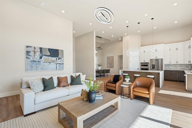 living room with a towering ceiling and light hardwood / wood-style floors