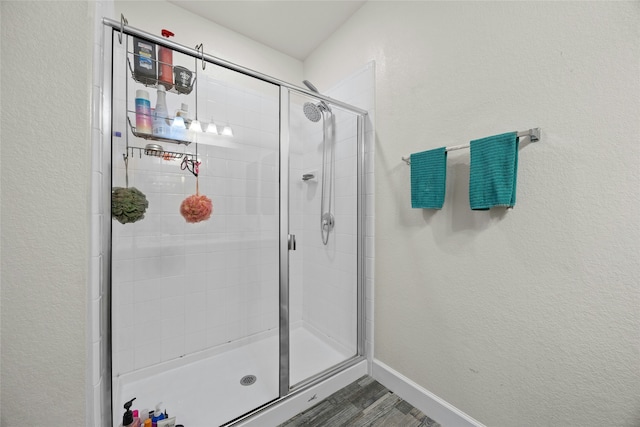 bathroom featuring wood-type flooring and a shower with door