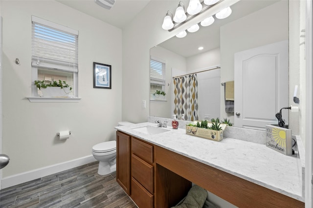 bathroom with hardwood / wood-style floors, vanity, curtained shower, and toilet