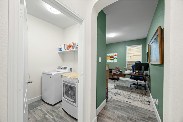 washroom with hardwood / wood-style flooring and washing machine and clothes dryer