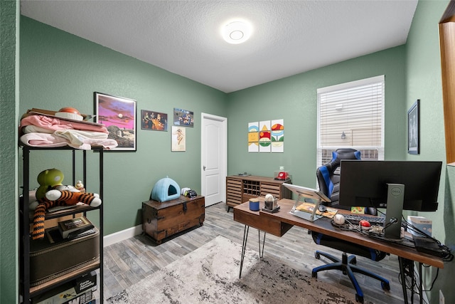 office area with hardwood / wood-style floors and a textured ceiling